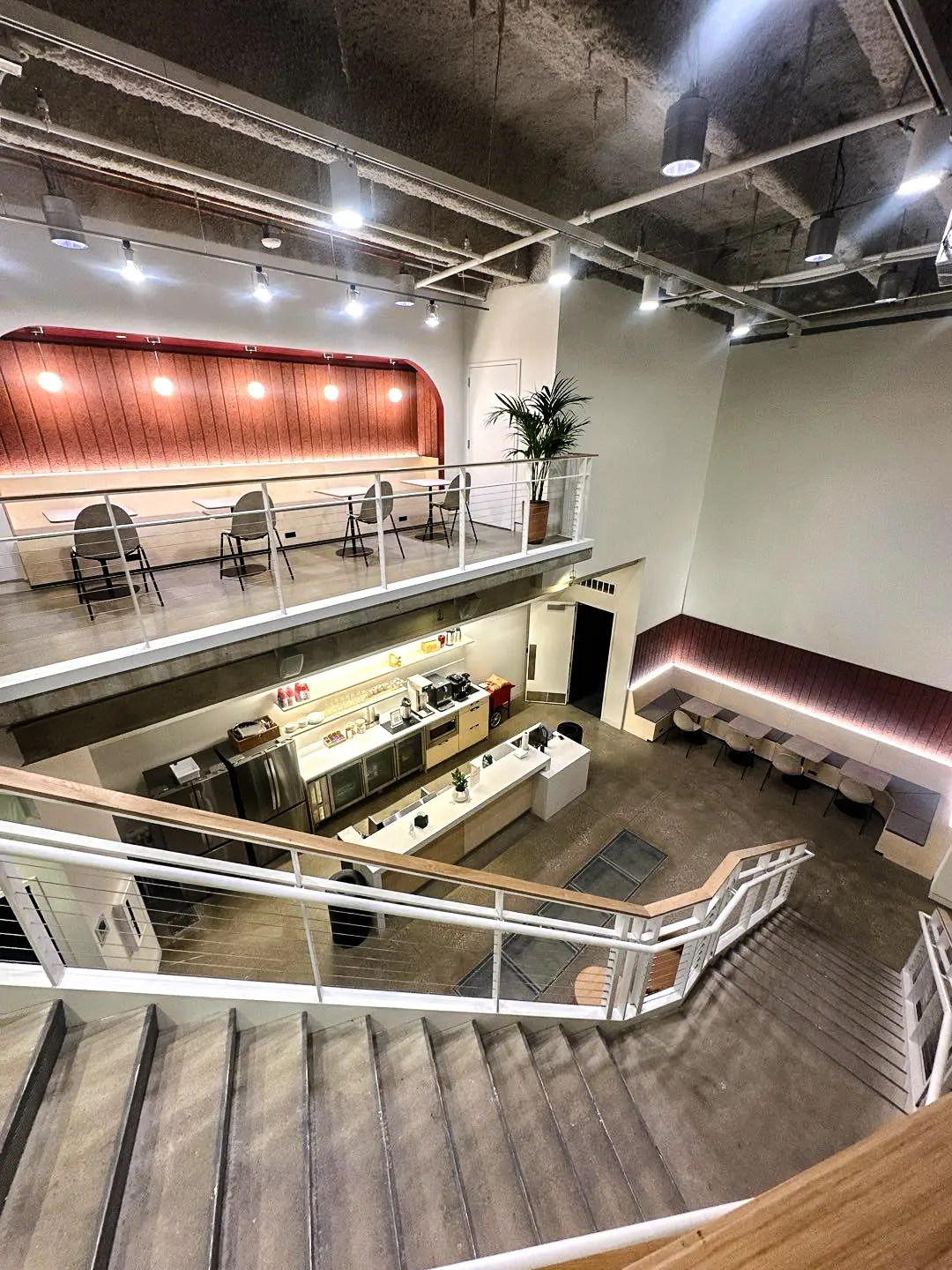 Detailed staircase view showcasing painted metal railings, exposed concrete surfaces, and clean commercial finish work throughout the building interior.