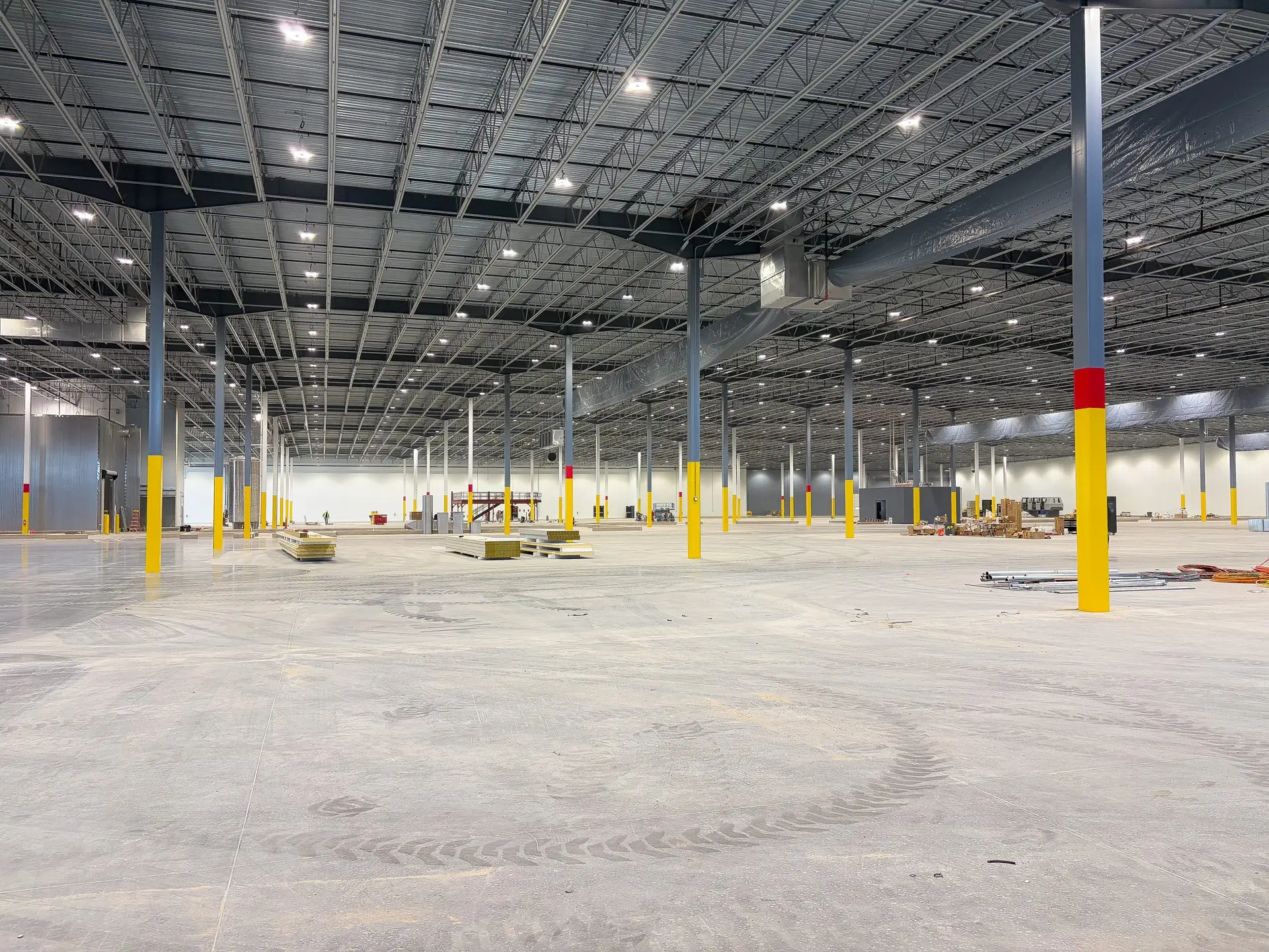 Warehouse interior with safety yellow steel column painting for visibility in large manufacturing facility
